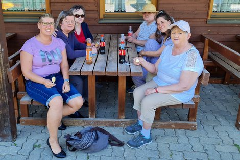 Sechs Frauen mit Eis und Getränken sitzen an einem Tisch.