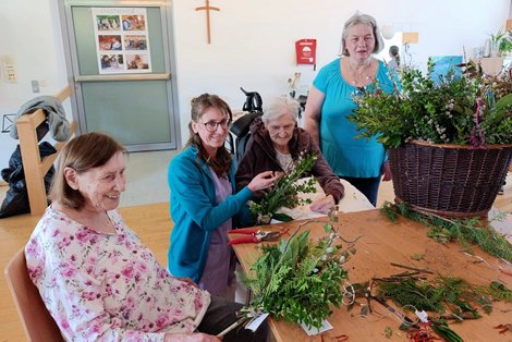 Ergotherapeutin Eva mit 3 Bewohnerinnen beim Palmbesenbinden
