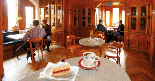 Blick in die Cafeteria mit Kaffee und Torte im Vordergrund