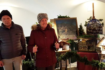 Ein Mann und eine Frau stehen vor einer Glaskastenkrippe.