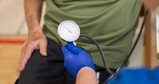 Mitarbeiterin misst Blutdruck des Bewohners