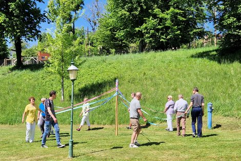 BewohnerInnen und PSD zeigen Bändertanz