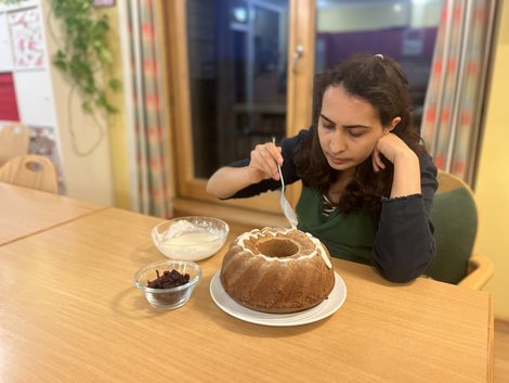 Bewohnerin Souzan streicht Zitronenglasur auf den Kuchen