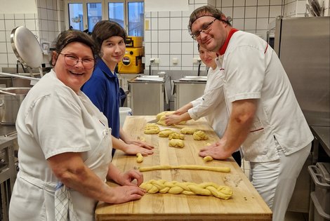 Küchenteam beim Striezelflechten