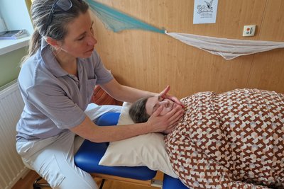 Physiotherapeutin massiert/streichelt Bewohnerin das Gesicht