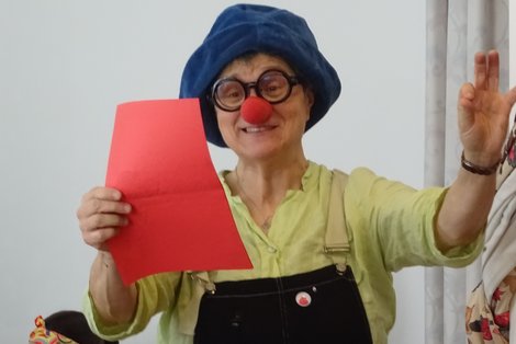 Clown mit roter Nase liest Gedicht vor