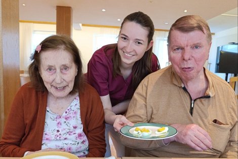 Ergotherapeutin Verena Poinstingl und BewohnerInnen beim Ostereier essen