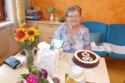 Geburtstagskind Leopoldine Gruber mit Torte und Blumen