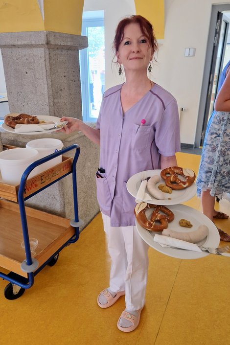 PSD-Mitarbeiterin beim Servieren von Weißwurst und Brezn