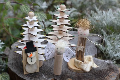 Holzfiguren, die einen Schneemann, Nadelbäume und Engel darstellen