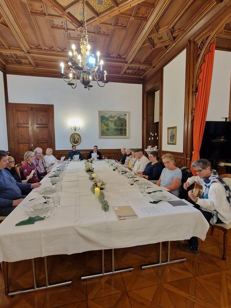 Gruppenfoto ehrenamtliche MitarbeiterInnen bei Tisch