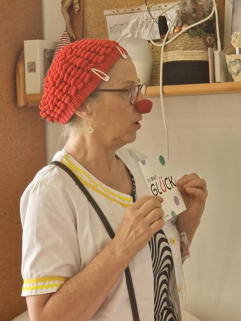 1 CliniClown zeigt Schild