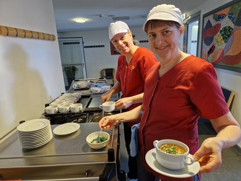 2 Küchenmitarbeiterinnen beim Anrichten der Speisen