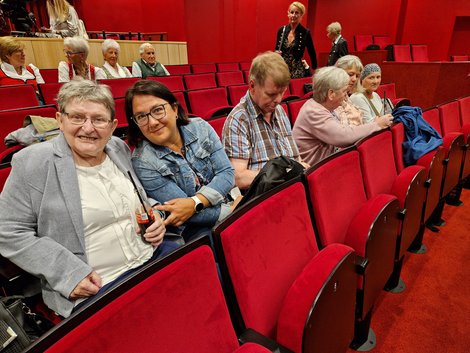 Gruppe auf roten Polstersitzen im Theater Bad Hall