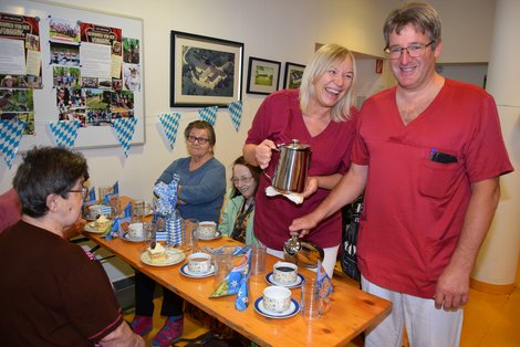 2 MitarbeiterInnen verteilen Kaffeejause an Bewohnerinnen