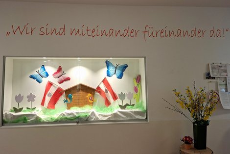 Nische in der WG Laakirchen mit Maibaumschild und Österreichfahnen