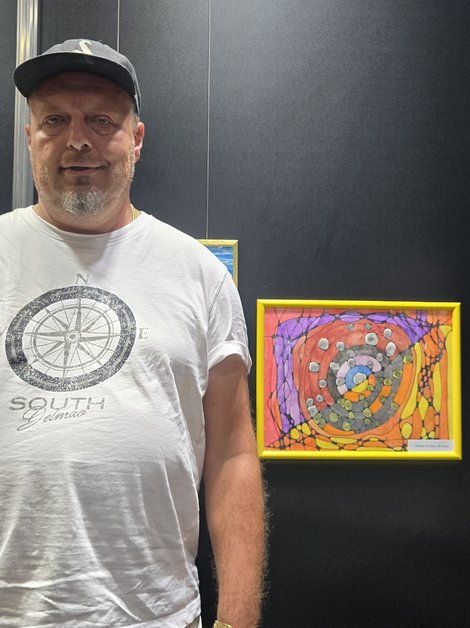 Bewohner vor seinem ausgestellten Kunstwerk