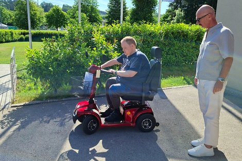 Bewohner auf Seniorenfahrzeug mit Mitarbeiter Fa. Carello