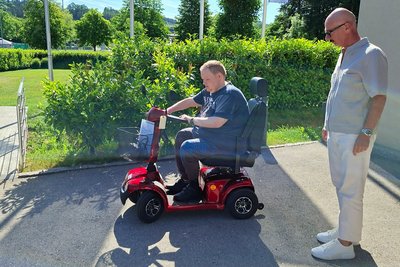 Bewohner auf Seniorenfahrzeug mit Mitarbeiter Fa. Carello