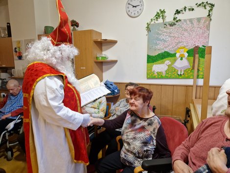 Nikolaus gibt Bewohnerin die Hand.