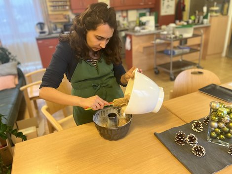 Bewohnerin Souzan füllt Teig in die Form 