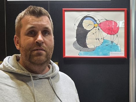 Bewohner vor seinem ausgestellten Kunstwerk
