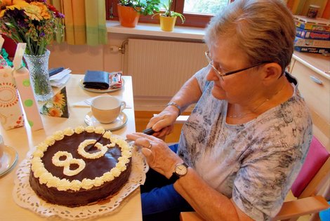 Leopoldine Gruber schneidet Torte an