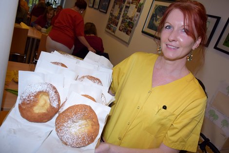 Mitarbeiterin hält Tablett mit Bauernkrapfen