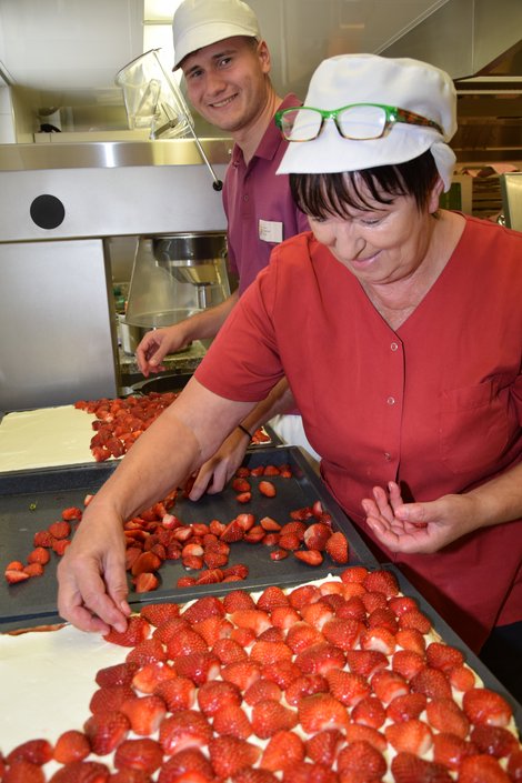 Erdbeerschnitte wird mit Erdbeeren belegt.