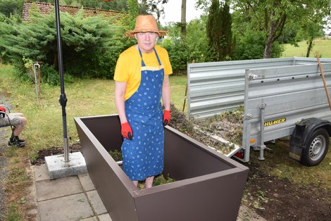 Bewohner stampft Äste im Hochbeet