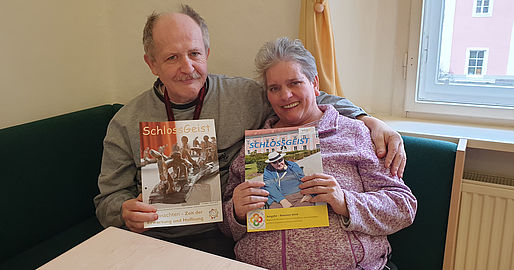 Mann und Frau mit der Hauszeitung in der Hand