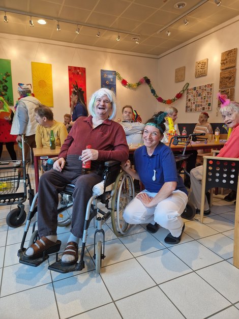 Bewohner im Rollstuhl und Mitarbeiterin beim Faschingsfest