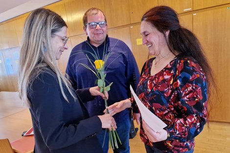 Bürgermeisterin Katrin Krenn überreicht Michaela Neumayer eine gelbe Rose. Im Hintergrund PD Schwarzlmüller.