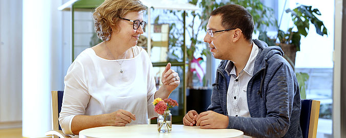 Bewohner im Gespräch mit einer Mitarbeiterin