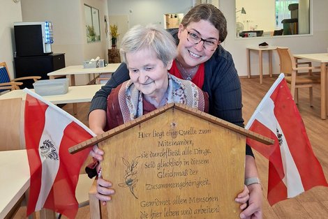 Bewohnerin und Mitarbeiterin mit Maibaumschild