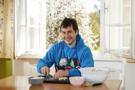 Bewohner Pablo beim Schneiden von Lebensmitteln