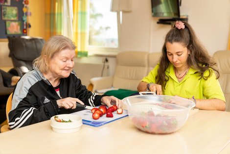 Frauen schneiden Erdbeeren