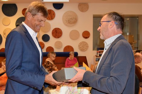Dir. Konrad überreicht Mag. Silber ein Geschenk