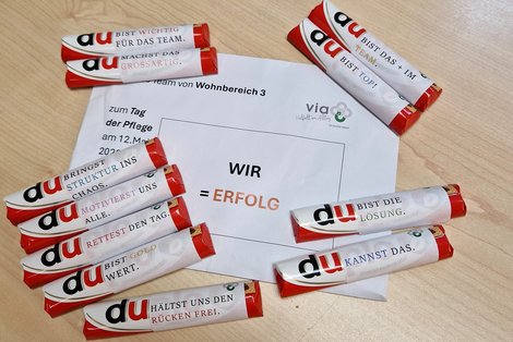 Kuvert mit der Aufschrift "WIR = Erfolg" und viele Duploriegel