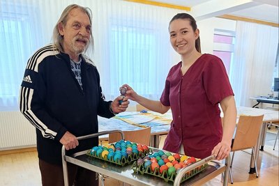 Ergotherapeutin Verena Poinstingl und Bewohner Andi mit vielen bunten Ostereiern