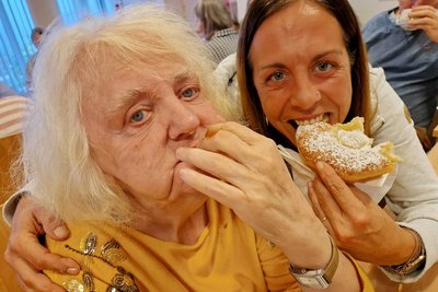 Bewohnerin und Mitarbeiterin beißen in den Bauernkrapfen