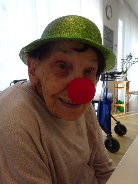 Bewohnerin mit roter Clownnase und Hut