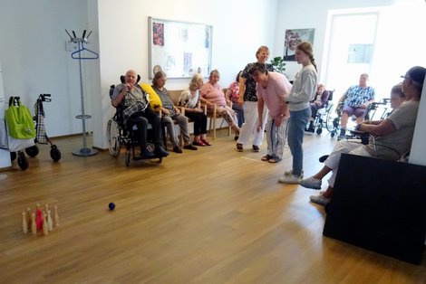 Gruppenfoto der Hobbykegler während Ball auf Kegel zurollt