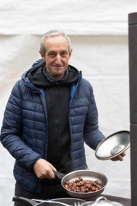 Mann mit Maroni in der Pfanne