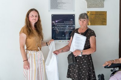 LPBZ-Geschäftsführerin Mag.a(FH) Christina Schwarzberger enthüllt mit LPBZ Schloss Gschwendt-Bewohnerin Gerlinde Zoitl die Gedenktafel zur Erinnerung an die in der NS-Zeit in Hartheim umgekommenen BewohnerInnen.