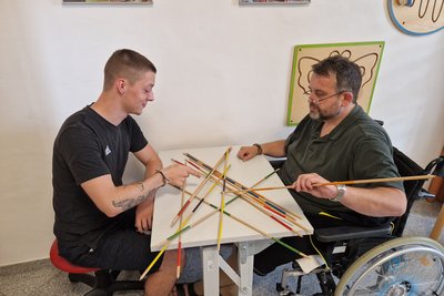 Praktikant spielt mit Bewohner Mikado