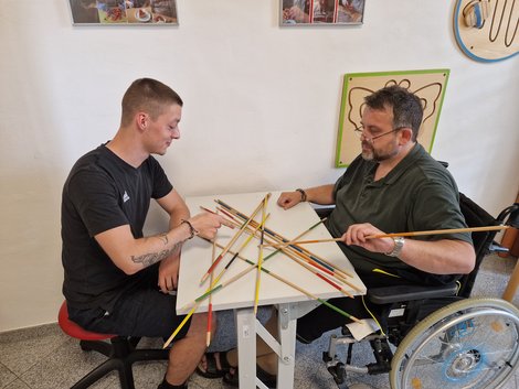 Praktikant spielt mit Bewohner Mikado