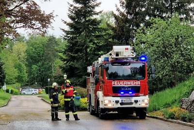 Feuerwehrmänner neben Feuerwehrauto