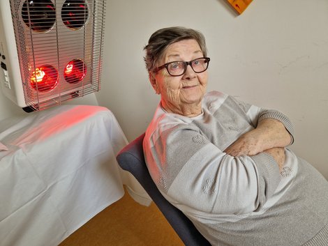 Bewohnerin vor Wärmelampe