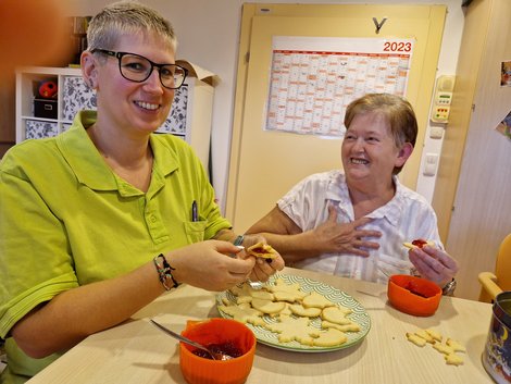 Kristina und Bewohnerin beim Kekse bestreichen